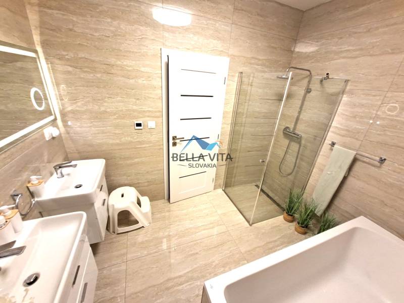 Ein Badezimmer in einem Einfamilienhaus mit Badewanne, Dusche und Doppelwaschbecken.