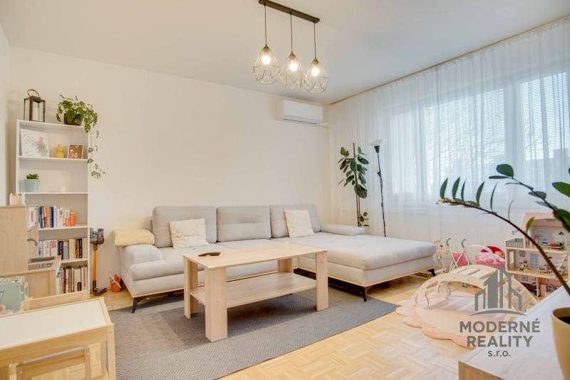 Helles Wohnzimmer mit Sofa und Holzboden in einer 3-Zimmer-Wohnung.