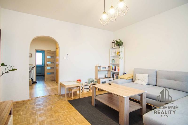 Wohnzimmer in einer 3-Zimmer-Wohnung mit Holzboden und hellen Möbeln.