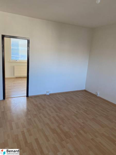 Ein Zimmer in einer 3-Zimmer-Wohnung mit weißen Wänden und einem Boden in Holzoptik.