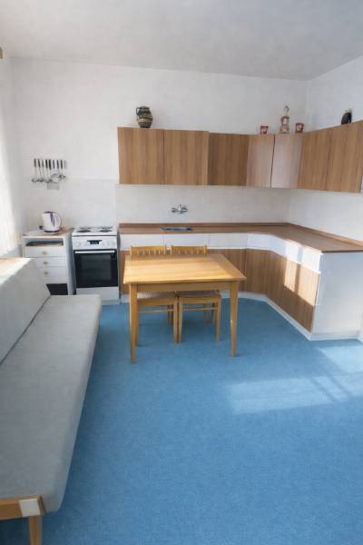 Eine Küche in einem Einfamilienhaus mit blauem Teppich und Holzschränken.