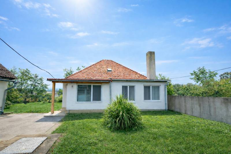 Ein Einfamilienhaus in Veľké Ripňany mit Garten, Schrägdach und Rasenhof.