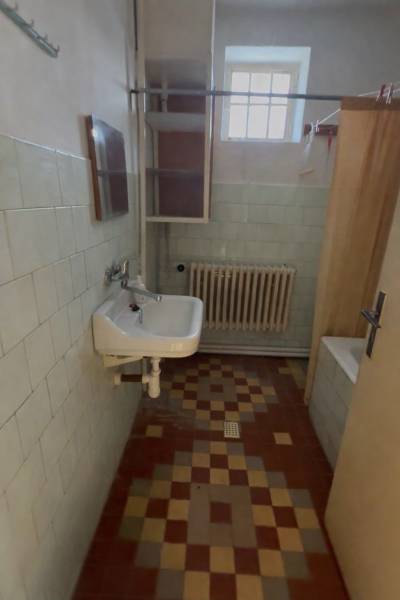 Badezimmer mit Waschbecken, Spiegel und Heizkörper, Einfamilienhaus.