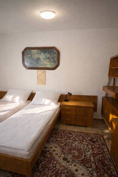 Schlafzimmer im Einfamilienhaus mit zwei Betten, einem Nachttisch und einem Bild an der Wand.