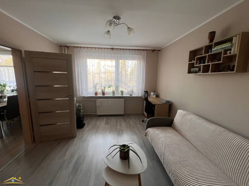 Wohnzimmer in einer 3-Zimmer-Wohnung mit Holzboden, Sofa und Couchtisch.