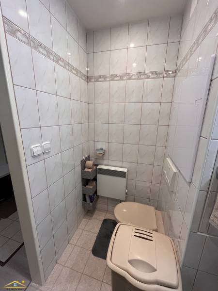 Badezimmer in einer 3-Zimmer-Wohnung mit Toilette, gefliest und mit einem Mülleimer.