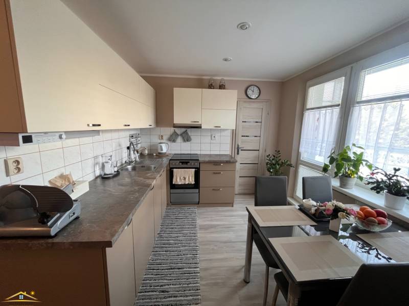 Küche in einer 3-Zimmer-Wohnung mit Tisch, Geräten und Pflanzen.