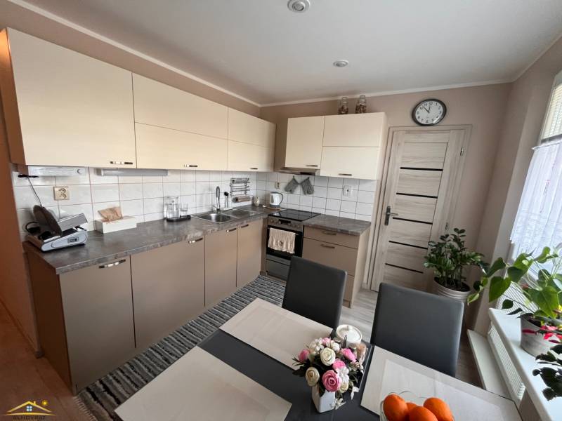 Küche in einer 3-Zimmer-Wohnung mit hellen Schränken und Esstisch.