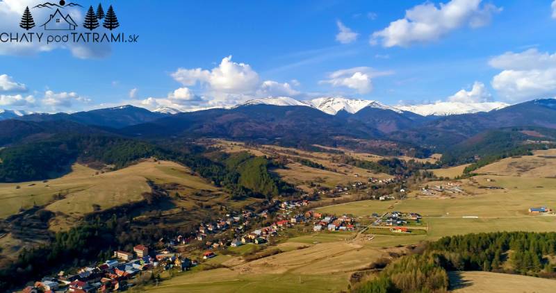 Luftaufnahme des malerischen Dorfes Dolná Lehota mit Berglandschaft im Hintergrund.