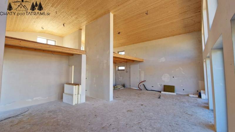 Das Innere der Hütte mit hoher Decke, roh bearbeiteten Wänden und feinen Holzdekorationen.