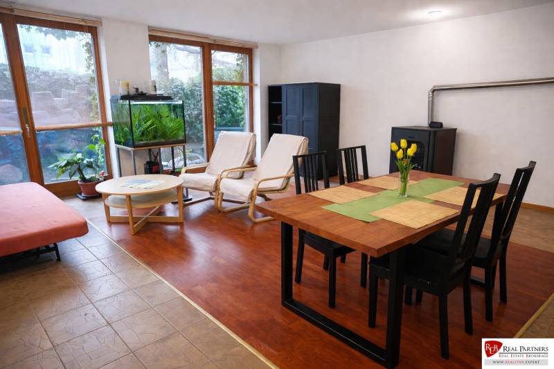 Wohnzimmer in einer 3-Zimmer-Wohnung mit Holzboden, Esstisch und Aquarium.