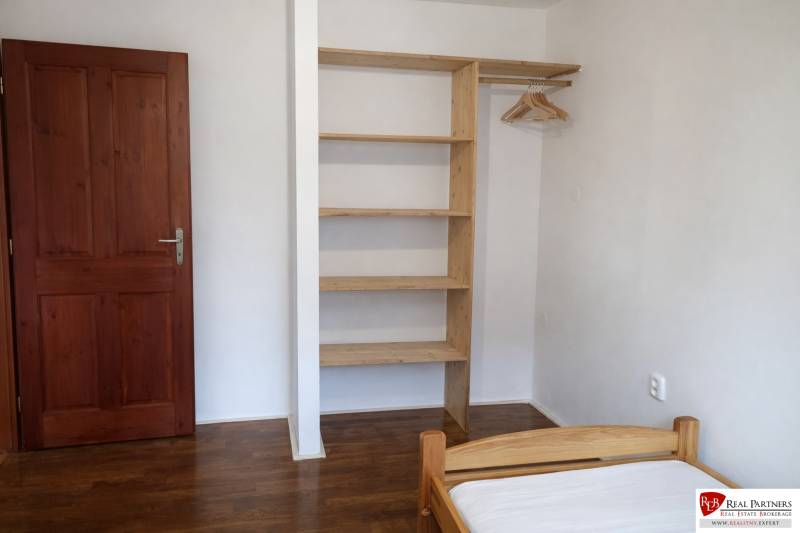 Schlafzimmer mit Holzelementen, Einbauschrank und Bett in einer 3-Zimmer-Wohnung.