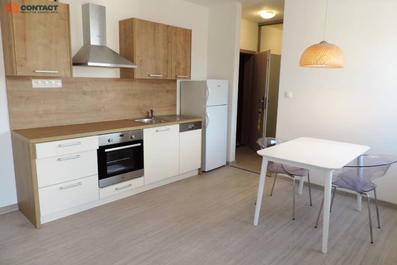 Küche in einem Studio-Apartment auf Bodona, Einfachheit mit Esstisch und grauen Stühlen.