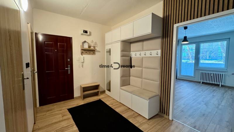 Flur mit Garderobenwand, Spiegel und Eingang zum Wohnzimmer, 3-Zimmer-Wohnung.