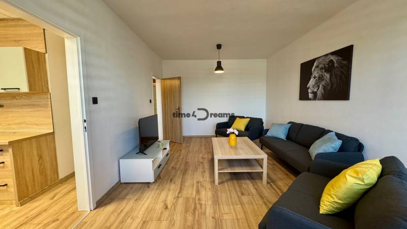 Wohnzimmer in einer 3-Zimmer-Wohnung mit Sofas und Holzboden.