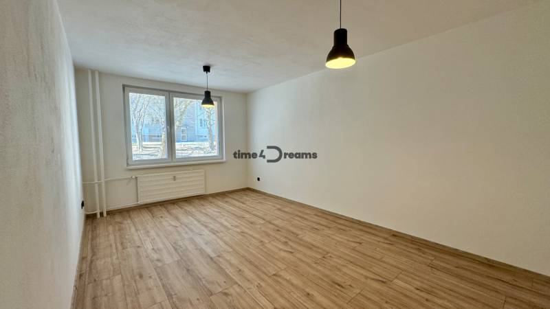 Ein geräumiges Zimmer in einer 3-Zimmer-Wohnung mit Holzboden und hängenden Lampen.