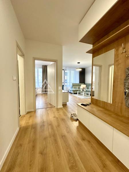 Der Flur in der 2-Zimmer-Wohnung mit einem Boden in Holzoptik und Einbaumöbeln.