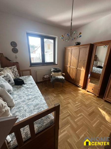 Ein Zimmer in einem Einfamilienhaus mit einem Holzboden und einem Bett.
