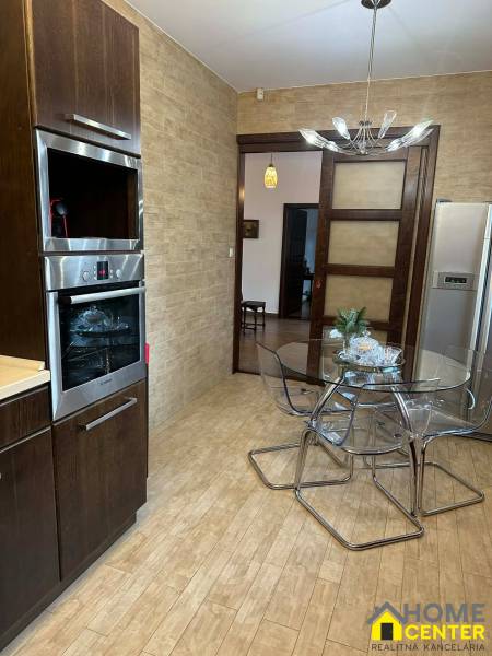 Eine Küche in einem Einfamilienhaus mit einem Holzboden und einem Glastisch.