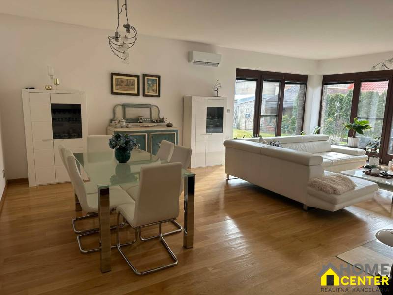 Wohnzimmer in einem Einfamilienhaus mit Holzboden und weißen Möbeln.