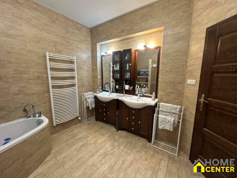 Badezimmer in einem Einfamilienhaus mit Holzboden und zwei Waschbecken.