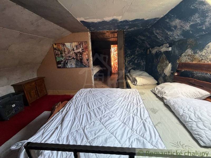 Dachbodenschlafzimmer in einem Einfamilienhaus mit einem Bild und einer blauen Wand voller Muster.