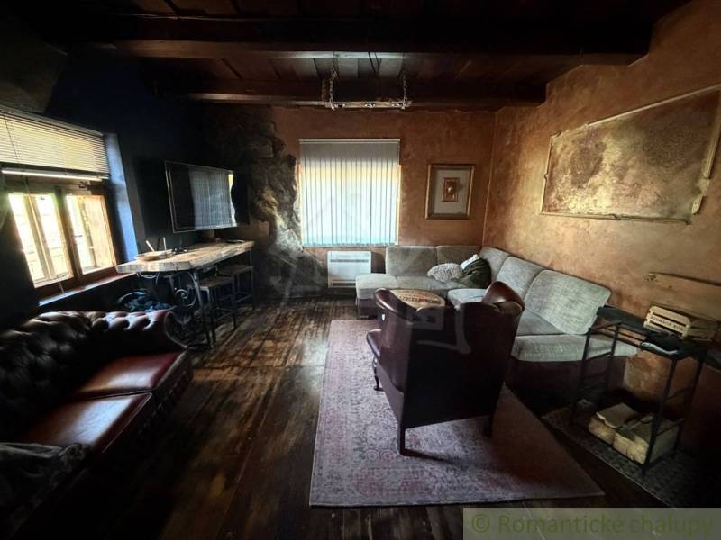 Wohnzimmer in einem Einfamilienhaus mit Holzboden und bequemen Sitzgelegenheiten.