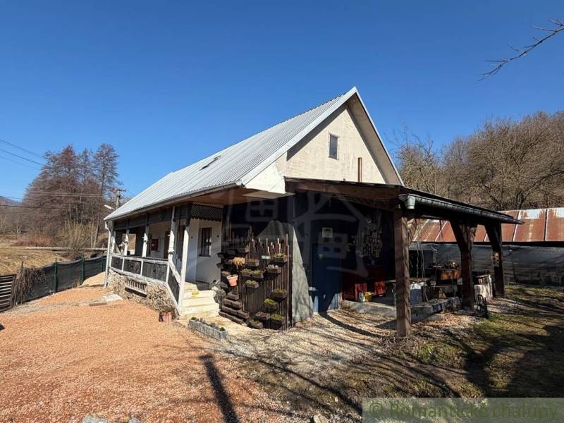 Ein Einfamilienhaus in Ratkovské Bystré mit einem Satteldach und einer Holzveranda.