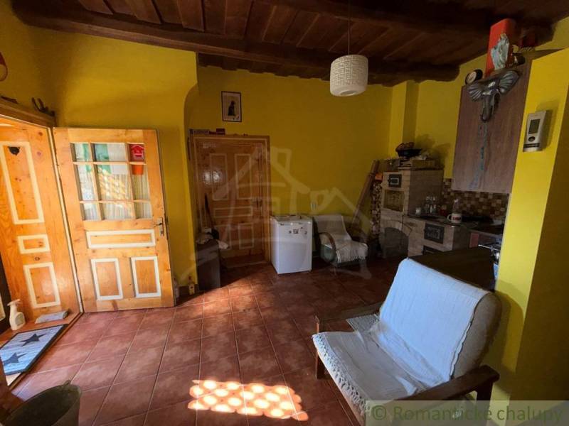 Ein Zimmer in einem Einfamilienhaus mit einem Ziegelboden, einer Holzdecke und gelben Wänden.