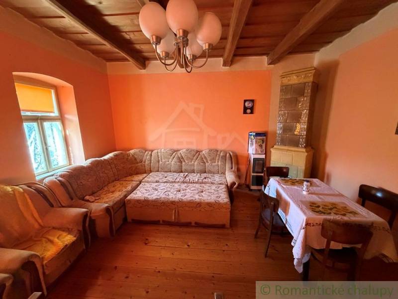 Wohnzimmer mit Ecksofa, Holzboden und Kachelkamin in einem Einfamilienhaus.