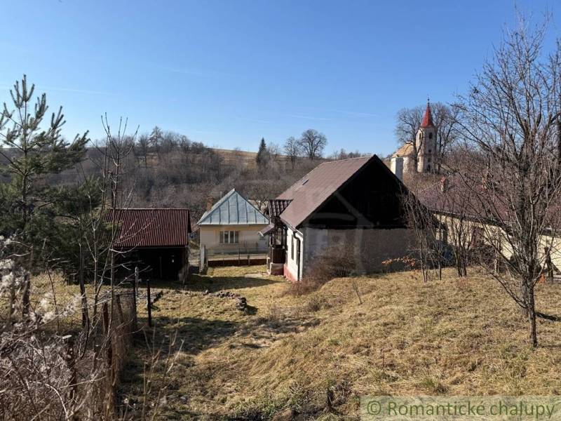Ein Einfamilienhaus in Lipovec mit einem Kirchturm im Hintergrund, umgeben von hügeliger Landschaft.