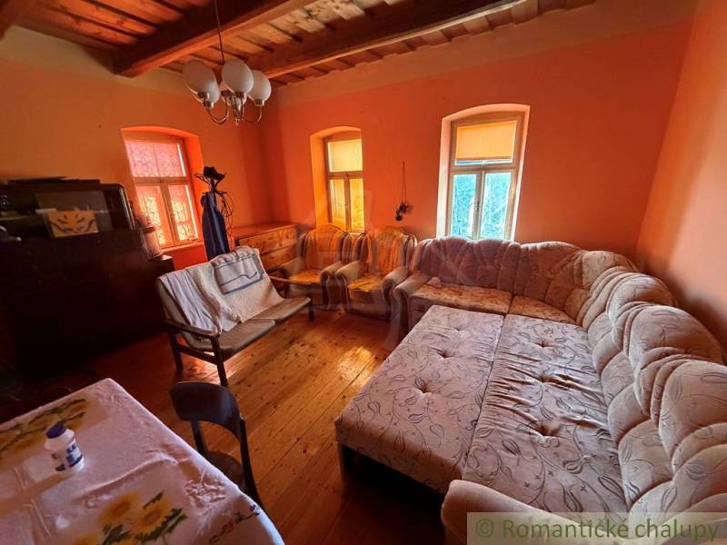 Wohnzimmer in einem Einfamilienhaus mit großem Sofa und Boden in Holzoptik.