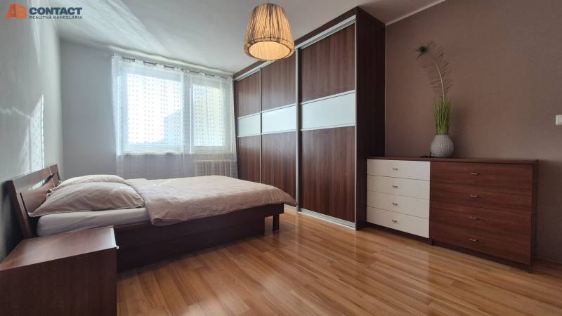 Schlafzimmer mit Bett und Einbauschrank, 2-Zimmer-Wohnung, Boden mit Holzdekor.