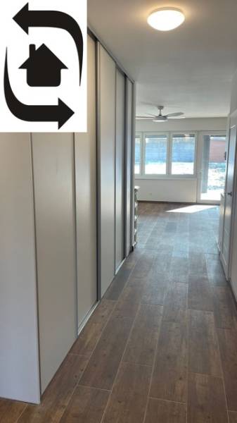 Flur in einem Einfamilienhaus mit Holzboden, großen Fenstern, Einbauschränken.