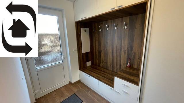 Ein Kleiderschrank mit Kleiderbügeln und Schränken, ein Boden mit Holzdekor. Ein Einfamilienhaus.