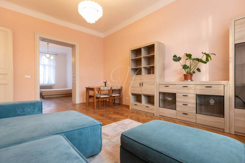 Wohnzimmer in einer 3-Zimmer-Wohnung mit Holzboden und pastellfarbenen Wänden.