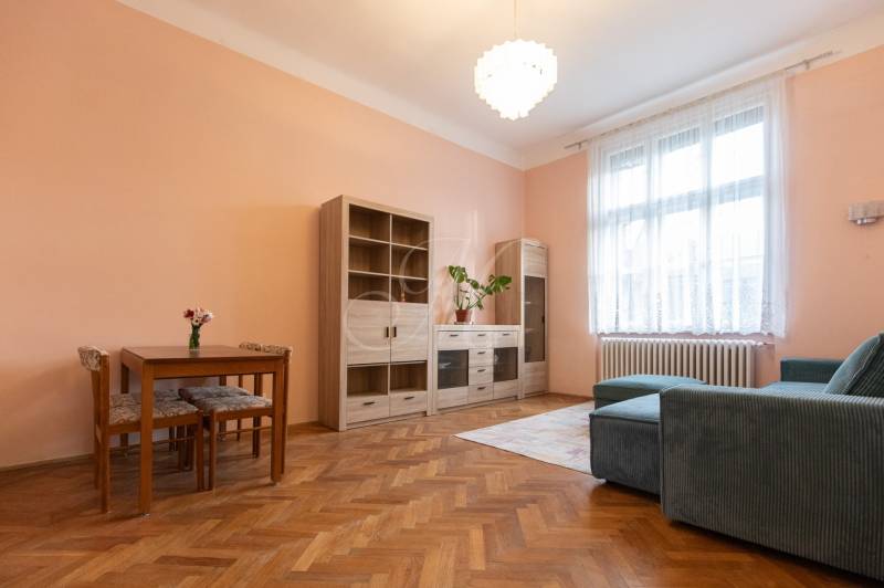 Wohnzimmer in einer 3-Zimmer-Wohnung mit Holzboden, Sofa und Möbeln.