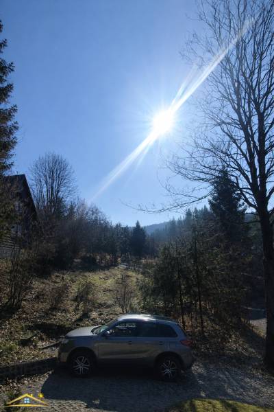 Ein sonniger Tag bei der Hütte in Oščadnica, ein Auto geparkt in der natürlichen Umgebung.