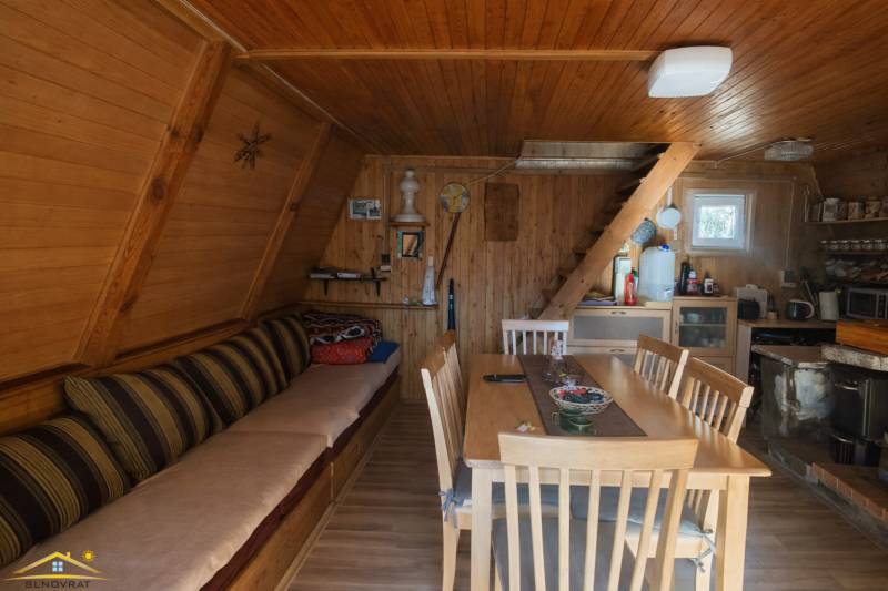Innenraum einer Hütte mit Holzverkleidung, Treppen und Boden mit Holzdekor.