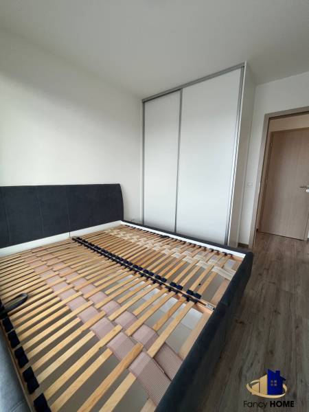 Schlafzimmer in einer 3-Zimmer-Wohnung mit Bettrahmen und Einbauschrank.