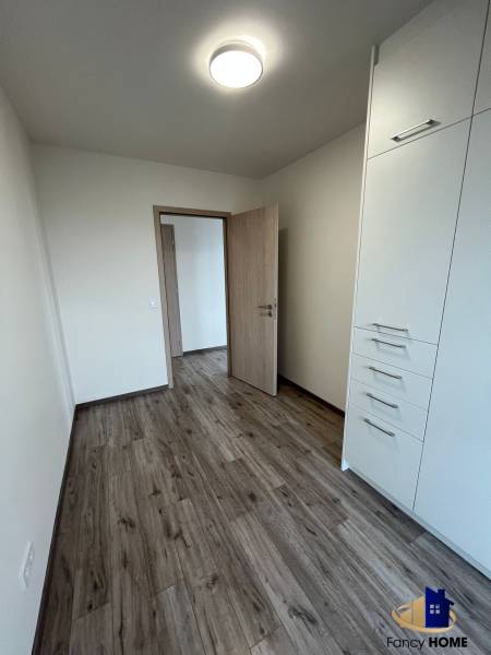 Ein Zimmer in einer 3-Zimmer-Wohnung mit Holzboden und eingebautem Stauraum.