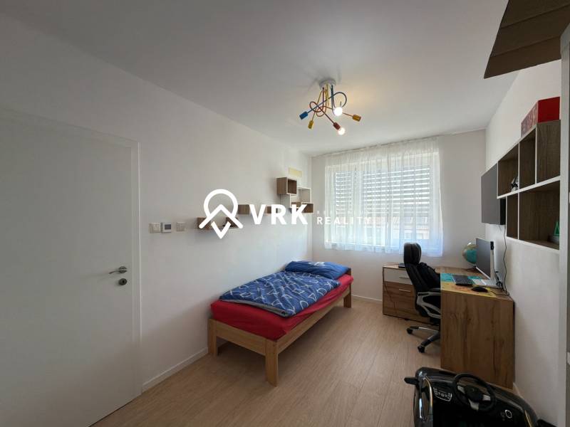 Kinderzimmer in einer 3-Zimmer-Wohnung mit Holzboden, Schreibtisch, Bett.