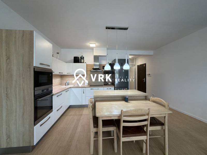 Küche in einer 3-Zimmer-Wohnung mit Holzboden und Esstisch.