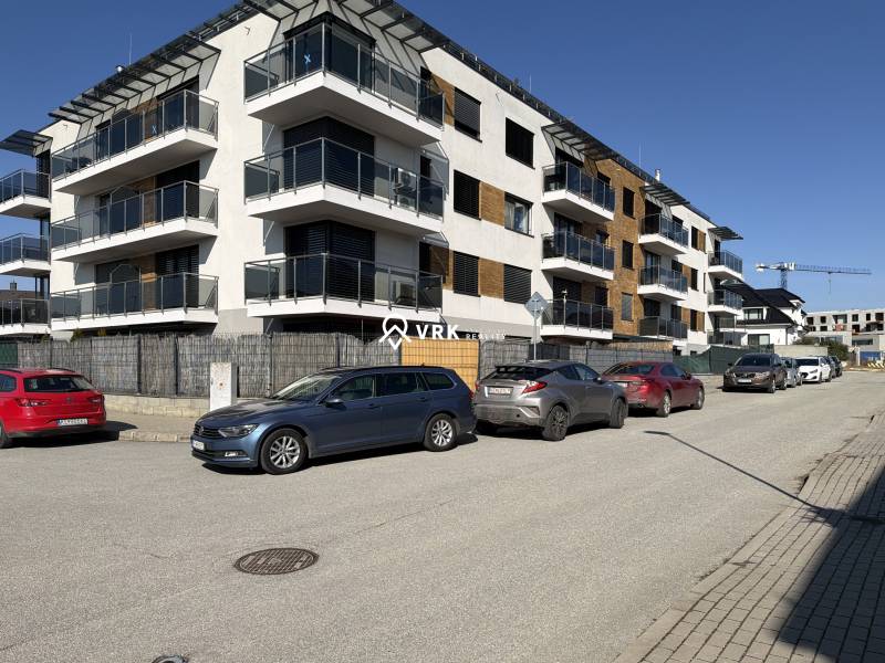 Neue Wohngebäude in der Topoľčianska-Straße in Košice, Stadtteil Západ, mit Autos, die vorne geparkt sind.