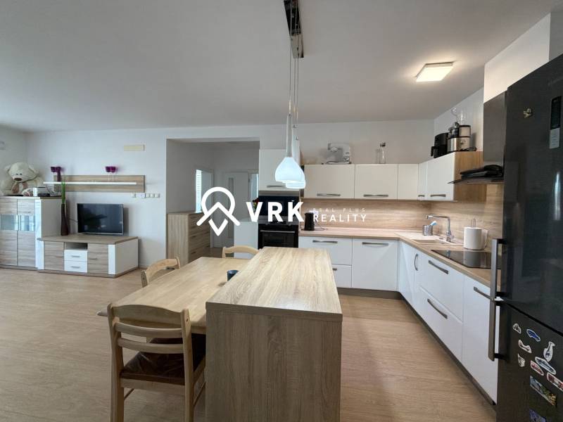 Küche in einer 3-Zimmer-Wohnung, Boden mit Holzdekor, moderne Geräte und Esstisch.