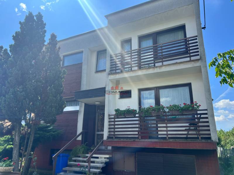 Einfamilienhaus in der Tálová-Straße in Veľké Orvište mit zwei Balkonen, Bäumen und einer Garage.