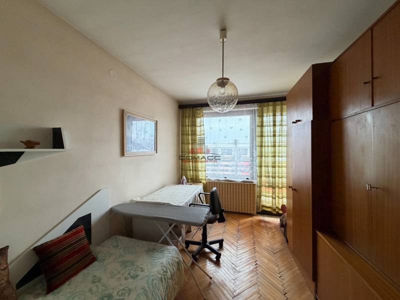 Ein Zimmer in einem Einfamilienhaus mit einem Holzboden, einem Sofa und einem großen Schrank.