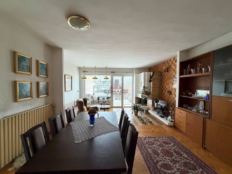 Wohnzimmer in einem Einfamilienhaus mit Holzboden, Esstisch und Kamin.