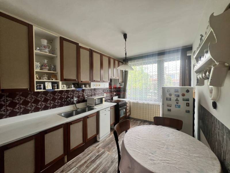 Eine Küche in einem Einfamilienhaus mit Holzschränken, einem runden Tisch und einem Boden mit Holzdekor.