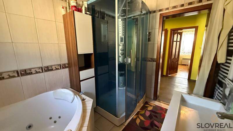 Badezimmer mit Badewanne und Dusche im Einfamilienhaus.